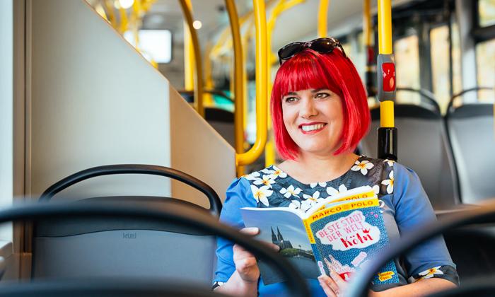 Junge Frau liest ein Buch im Bus