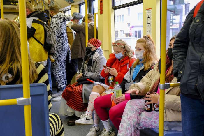 Kostmierte Fahrgste mit Maske in der Stadtbahn
